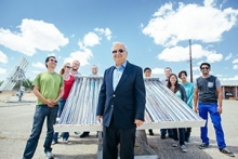 Professor Roland Winston and students posing by solar machinery
