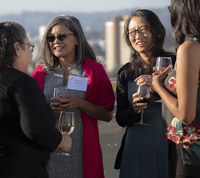 Manilay and Song speaking with dinner attendees