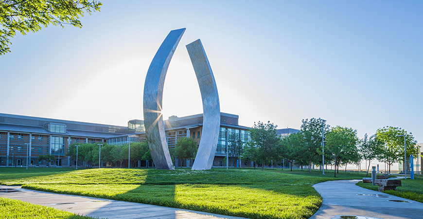 Photo of UC Merced Beginnings sculpture and buildings