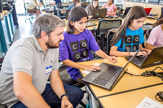 Teaching Professor Angelo Kyrilov works with area high school students on their computer coding skills.