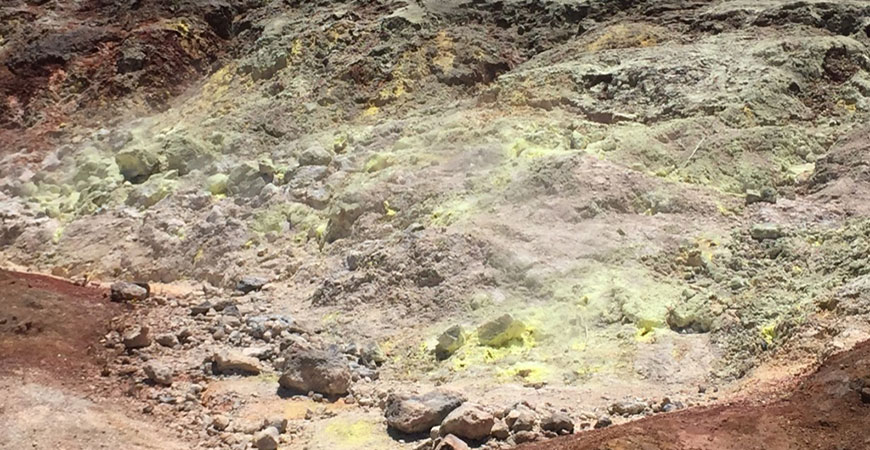A picture of a soil chronosequence in Hawaii shows yellow sulfur-rich soil that has built up over millions of years.